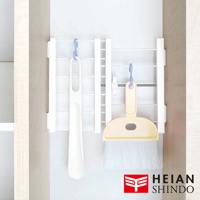 圖片右下角有HEIAN SHINDO品牌標誌，左側掛著一隻白色長柄鞋拔，右側掛著一個黃色小畚箕和刷子，它們都掛在一個白色的伸縮縫隙置物架上。