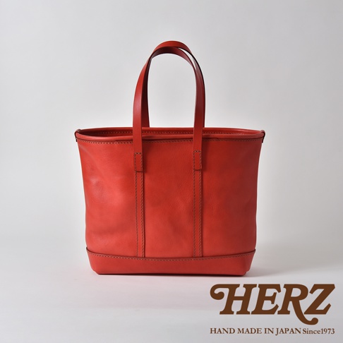 紅色皮革經典托特包，設有雙提把，簡約設計，底部有加固皮革。