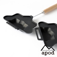 黑色的熱壓三明治烤夾，造型為星星狀，烤盤內有兩個凹槽，其中一個連接金屬手柄，手柄末端為木質。