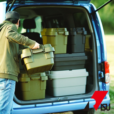 綠色、黑色和淺灰色的可堆疊塑膠收納箱，裝載於藍色汽車後車廂中，一人正將一個綠色收納箱放入。