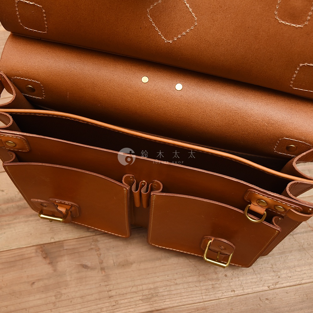 職人手作皮革旅行包 A-102，棕色，皮革材質，包款內部結構，有兩個前袋，附有金屬扣環，展示包包的細節與質感。