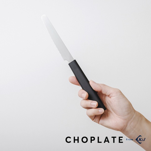 手持一把黑色握柄的鋸齒狀不鏽鋼刀，刀刃部分呈現銀色金屬光澤，刀背有一處凹槽設計。