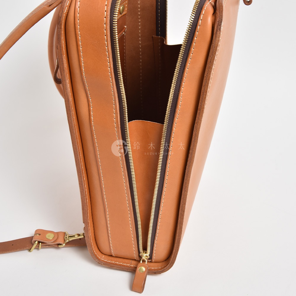 棕色皮革商務電腦後背包，拉鍊部分特寫，展示精緻縫線與金色拉鍊頭。