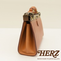 職人手作皮革復古口金兩用手提包，採用棕色皮革，側面展示包身輪廓和復古金屬鎖扣，手工縫線清晰可見。