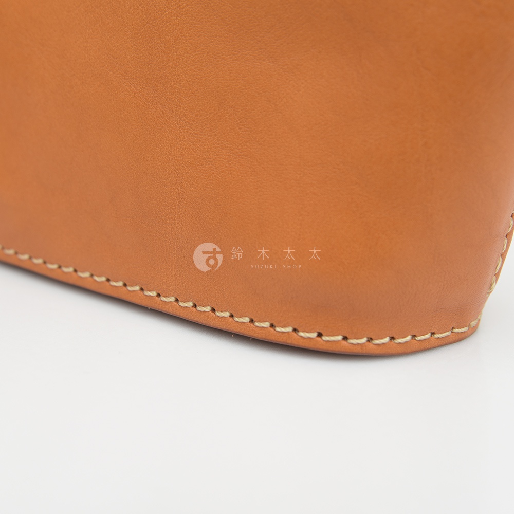 職人手作皮革三角收納包 KF-1，這款收納包採用光滑的淺棕色皮革製成，邊緣以米白色車線縫合，展現精緻工藝。