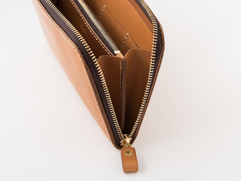 職人手作皮革長夾，淺棕色，採用拉鍊開合設計，露出內部隔層與細緻縫線，展現皮革質感。