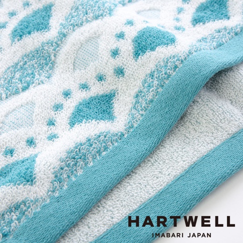 今治和風傳統紋樣言織毛巾，織有藍白相間菱形與圓點圖案，毛巾邊緣為藍色滾邊，材質柔軟，觸感細緻。