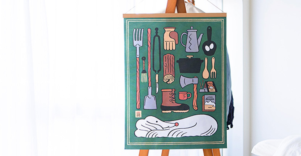 綠色帆布海報，印有各種露營和烹飪用具，如叉子、鍋子、斧頭、靴子，以及一隻俯臥的白色動物。