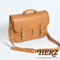 棕褐色皮革製成的雙用單肩包，帶有金色扣環和白色縫線，包款設計簡約，可肩背或手提。