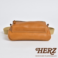 駝色皮革製成的兩用腰掛斜背包，設有拉鍊開口和單一主隔層，搭配米色織帶。