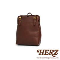 職人手作皮革後背包 R-143 加厚版，採用深棕色皮革，配有金色釦環和皮帶，設計簡潔大方。