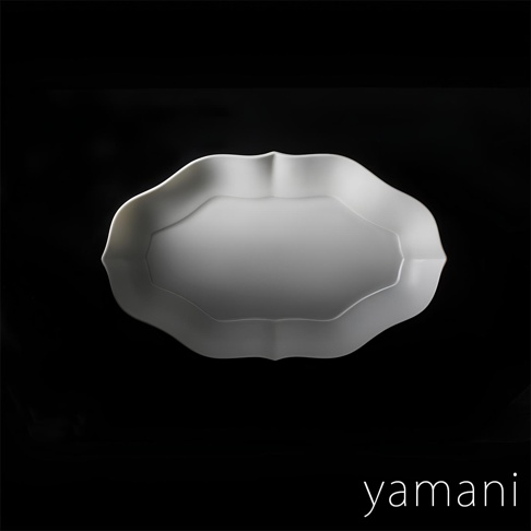 淡青白釉美濃燒輪花長盤，呈橢圓形，邊緣有輪廓狀的花瓣造型，表面光滑，顏色為淡青白色。