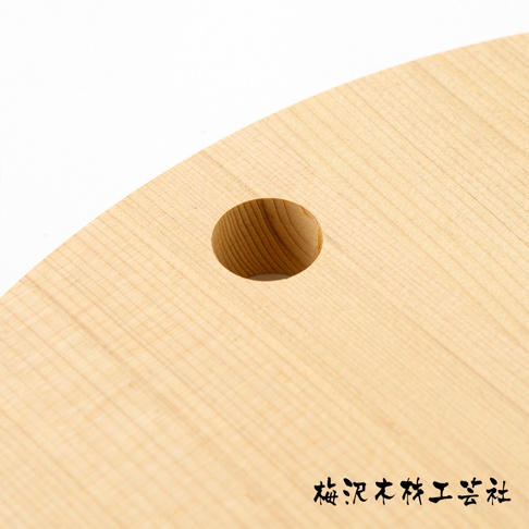 淺色木紋材質的圓形砧板，表面有清晰的木紋理路，一側有一個圓形掛孔，邊緣呈現弧形。