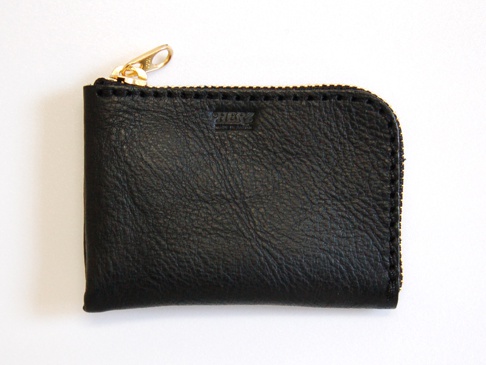 黑色軟皮革L型拉鍊卡片夾，表面有自然紋理，頂部有金色拉鍊頭，側邊縫線清晰。