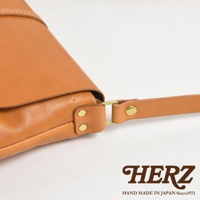 HERZ 品牌標誌與 Handmade in Japan Since 1973 字樣，以及皮革包的細節特寫