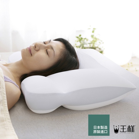 白色王樣の極柔枕，搭配天絲 TENCEL 枕套，枕頭呈現流線型設計，中間略凹，兩側隆起，材質觸感柔軟。