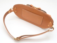 職人手作皮革拉鍊旅行斜背包，主體為淺棕色皮革，設有一個拉鍊開口和一個方形皮革貼片。配有可調節的淺棕色皮革斜背包帶，並以黃銅色金屬扣件連接。