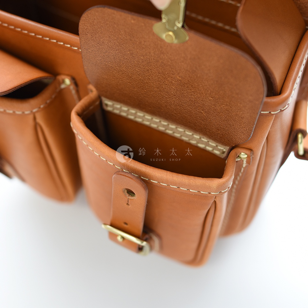 職人手作皮革經典雙扣郵差包，特寫內部細節，展現縫線與皮革紋理