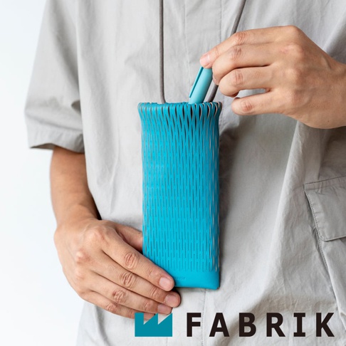 FABRIK 皮革隨形貼合伸縮小包，側邊條紋設計，以手部拿取筆狀物體的特寫視角呈現