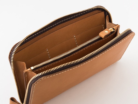 淺棕色皮革拉鍊長夾，內裡為淺棕色皮革，配有金色拉鍊和金色金屬配件，長夾內有夾層和卡槽。