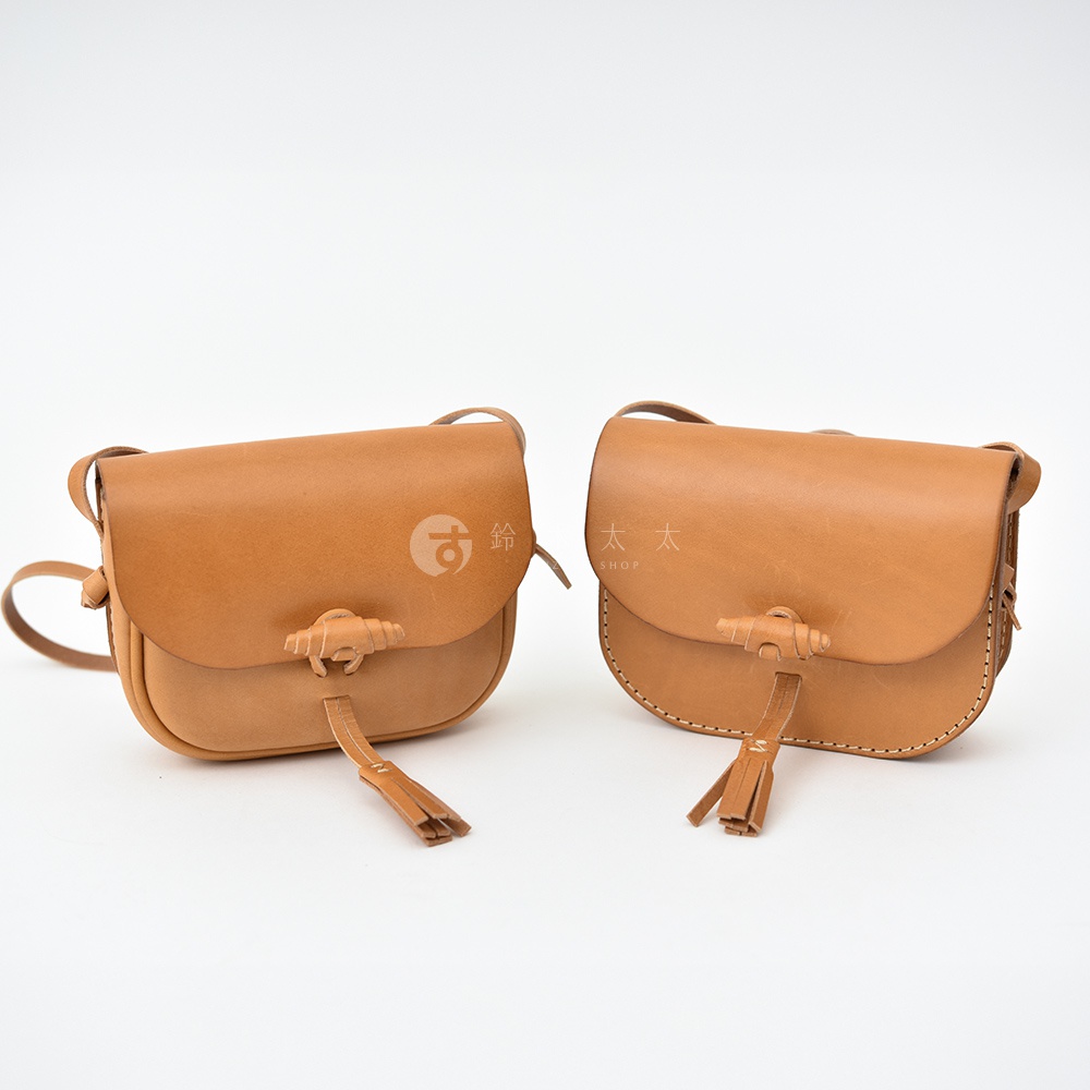 兩款皮革流蘇側背包，皆為棕褐色，採用手工皮革製作，帶有獨特的流蘇裝飾與木質鈕扣開合設計。