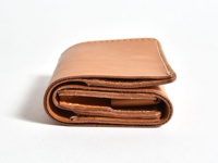一個棕色皮革三折式迷你短夾，展示其層疊的結構和精緻的縫線。