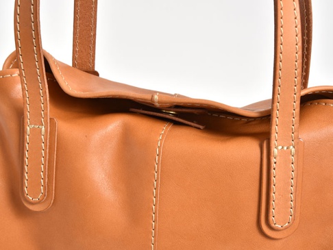 職人手作皮革直式肩背托特包，以淺棕色牛皮製成，設有對比色的縫線和皮革提把。