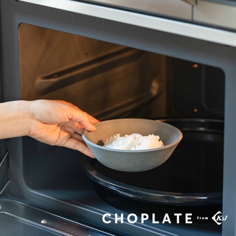 灰色CHOPLATE沙拉碗，裝有煮熟的米飯，一隻手正將其放入微波爐內。