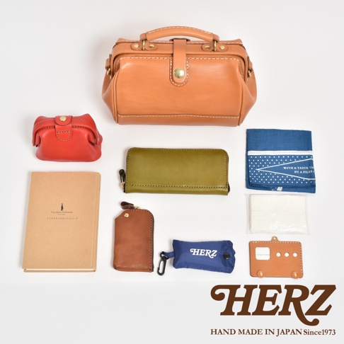 職人手作皮革口金醫生單肩包，呈現原色皮革光澤，搭配多樣尺寸與顏色的配件：紅色零錢包、綠色長夾、棕色鑰匙包、筆記本，以及藍色與白色方巾。