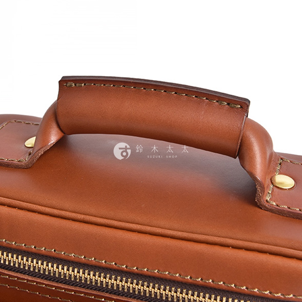 日本HERZ職人手作皮革厚實相機包的特寫，展示了其圓潤的頂部提把和拉鍊。