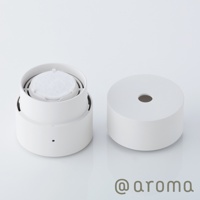 白色圓柱形替補棉片，置於打開的香氛機組件中，另一半圓柱形外蓋並排。