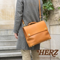 職人手作皮革旅行商務兩用波士頓包，採用天然棕色皮革，配有金屬鎖扣和加固底部。此款包包可肩背或手提，設計簡約實用。