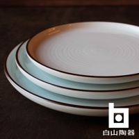 三層堆疊的白色陶瓷圓盤，表面有同心圓紋路，盤緣飾有深棕色細邊。