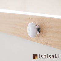 木製畫板上的白色圓形旋鈕，固定於淺木色木條上，旋鈕旁有金屬螺絲及墊圈。