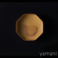 芥黃釉美濃燒八角盤，釉色溫潤，八角造型，邊緣呈現精緻的銀色線條，盤面有自然的暈染效果，材質為陶瓷。