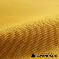 模式B： 金黃色斜紋布料特寫，布料表面有細緻紋理，下方有 AYANOKOJI 品牌標誌