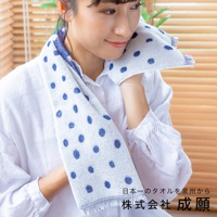 一位女性將藍白圓點圖案的嫘縈毛巾搭在肩上，毛巾觸感柔軟，邊緣有流蘇設計。
