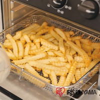 23L大容量氣炸烤箱 FVX-D18A 內部，裝滿了金黃色的波浪切薯條，薯條放在金屬網籃中，烤箱內部的黑色控制面板和銀色烤架清晰可見。