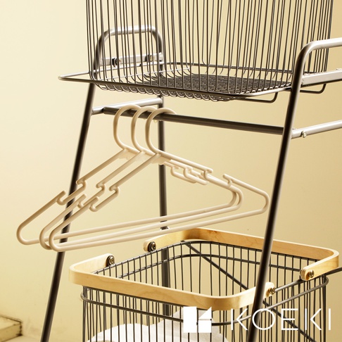 Mash移動式雙層分類洗衣置物籃，黑色金屬支架，上方有一個黑色線條編織的洗衣籃，下方掛有數個淺米色塑膠衣架，最底層有一個黑色金屬線條編織的洗衣籃，籃緣帶有木質邊框。