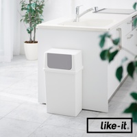 白色前開式寬版可疊垃圾桶，附灰色推蓋，置於廚房水槽旁，背景為白色廚櫃和綠色盆栽。