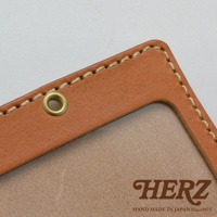 職人手作皮革橫式證件識別夾，採用淺棕色皮革，車線為米白色。證件夾邊緣有金屬孔，內部可見證件夾的淺色內襯。