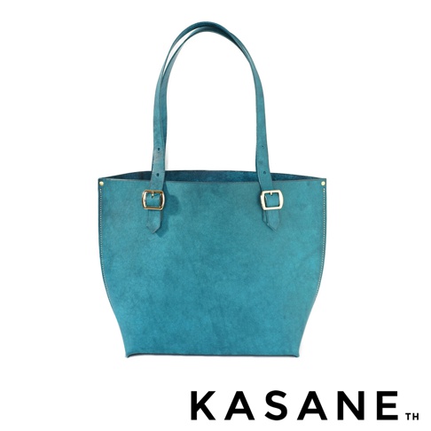 KASANE 品牌字樣，一個藍綠色皮革托特包，包包上有兩個金色搭扣和雙提把。