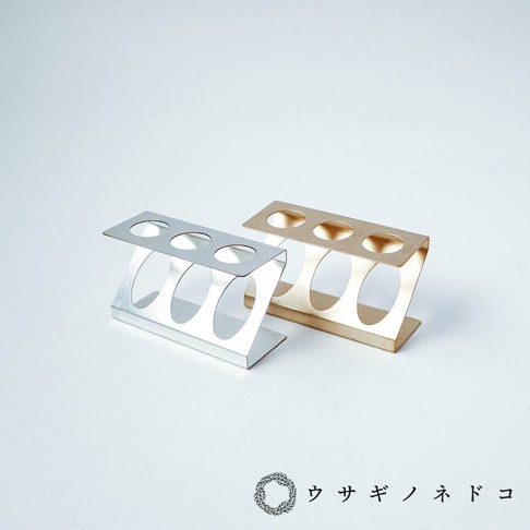 兩款試管瓶放置架，一款為銀色，另一款為金色，皆為金屬材質，結構簡潔，每款皆有三個圓形孔洞用於放置試管。