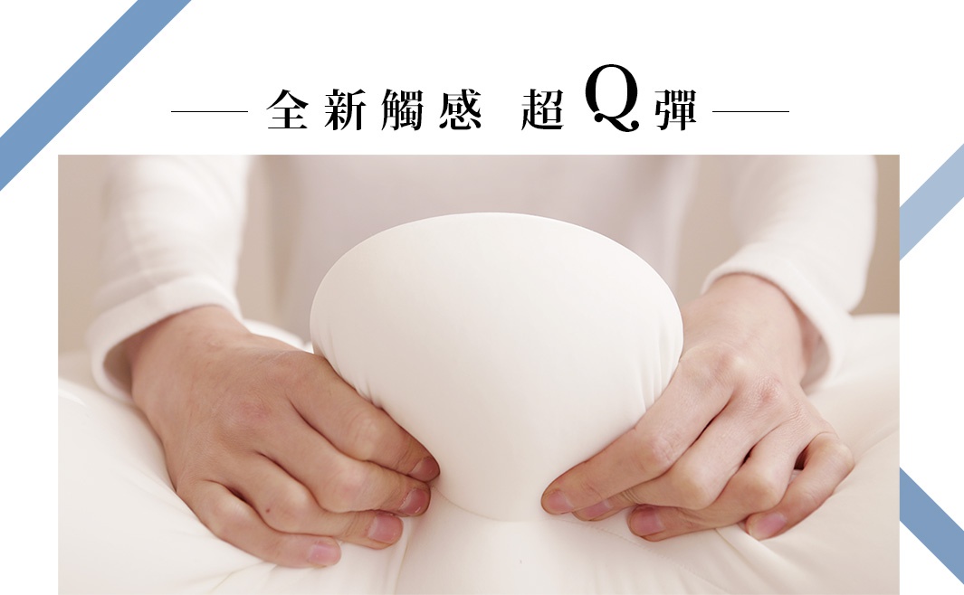 雙手正在按壓一個白色、柔軟的抱枕，展現其Q彈的材質。