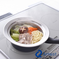 不鏽鋼蒸盤內盛有白菜、香菇、胡蘿蔔、豬肉片和烏龍麵，蒸氣從鍋中冒出，置於白色電磁爐上。