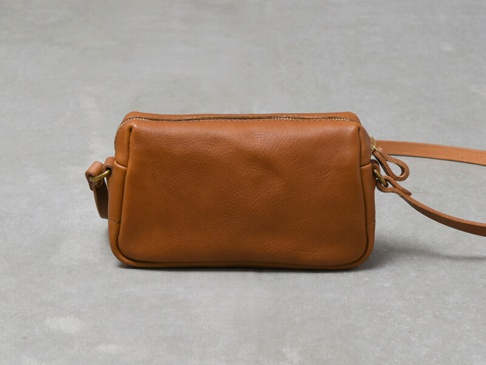 職人手作皮革Organ輕巧拉鍊單肩包 (G-80) S，呈現溫暖的淺棕色皮革，包體為長方形，頂部有拉鍊封口，側邊有金屬環連接細長的皮革背帶。