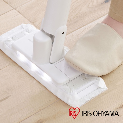 白色電動平板拖把 SWD-A，搭配米色拖鞋，在木質地板上使用。拖把頭鋪有白色清潔墊，帶有LED燈。