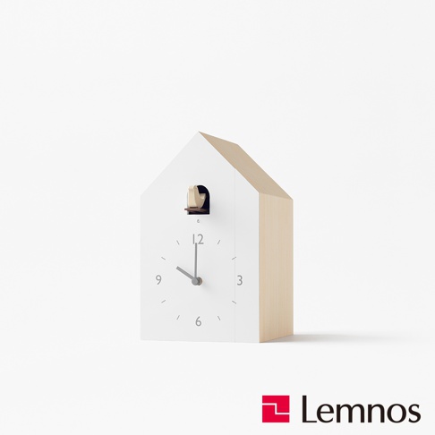 白色屋頂造型布穀鳥報時鐘，側面為淺木色，時鐘盤面為白色，設有時針、分針及時標，頂部有一個小窗戶，露出布穀鳥的木質機關。