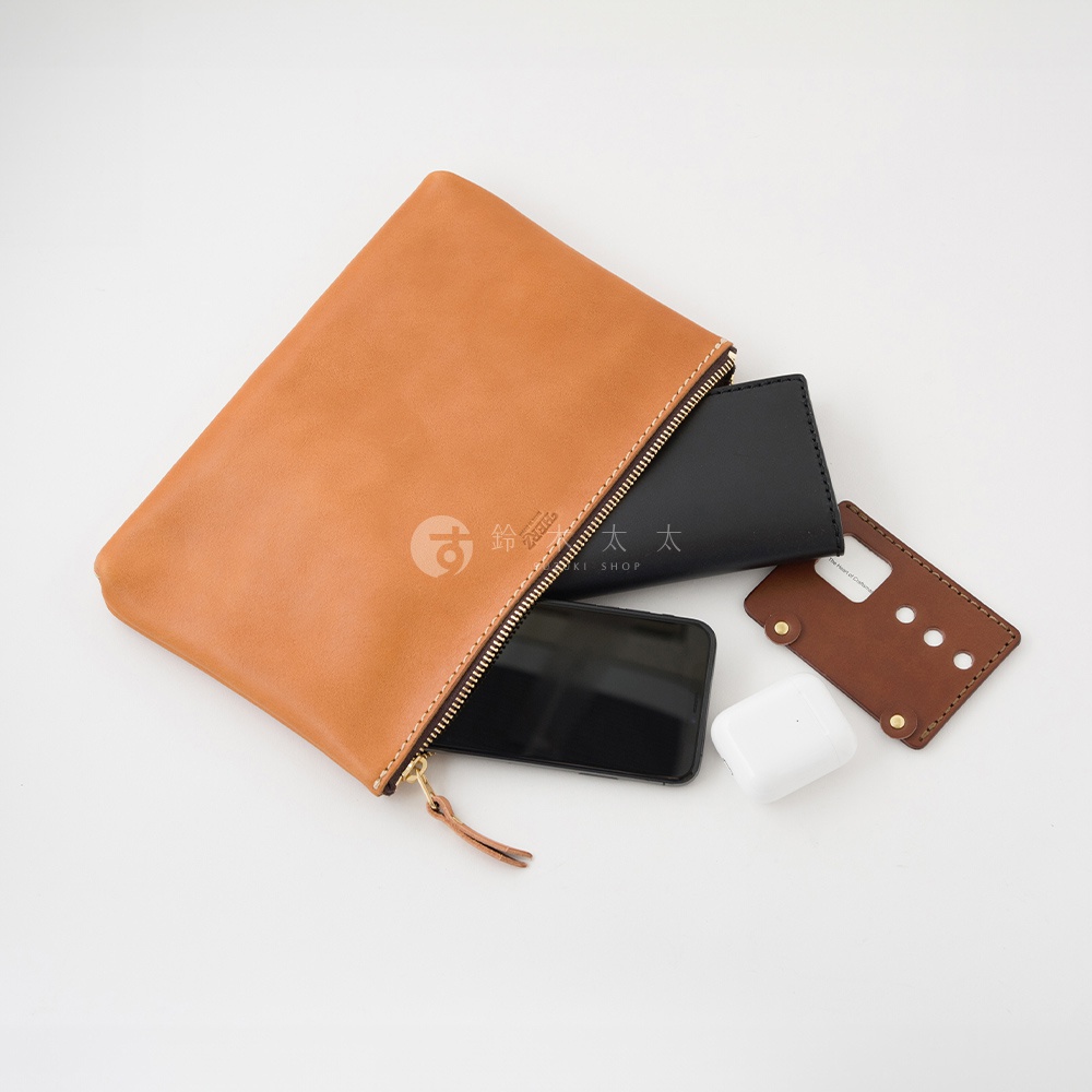 一個棕褐色皮革長方形拉鍊收納包，內有黑色手機、黑色小皮夾、白色無線耳機及一個棕褐色皮革卡套。