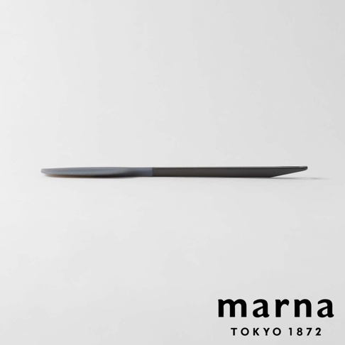 marna TRYANGGRIP 系列三角耐熱矽膠料理刮刀，展現為黑色和灰色拼接的長條狀物體，以平視角度橫放於白色背景上，品牌 logo marna TOKYO 1872 位於右下角。